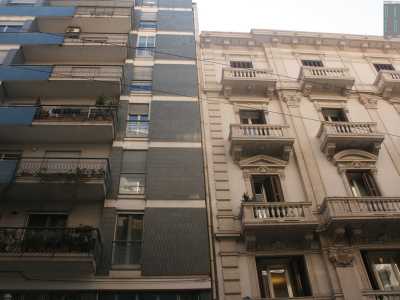 Foto 7. Ci spostiamo a questo punto su via Principe Amedeo. Qui, ad angolo con via Roberto da Bari, si trova un altro sfarzoso palazzo bianco riccamente decorato con balconi in pietra spessa e timpani dalle forme diverse: bellissimo, peccato che l�edificio debba stridere con una pi� alta abitazione moderna che va dal blu, al beige e al grigio scuro 